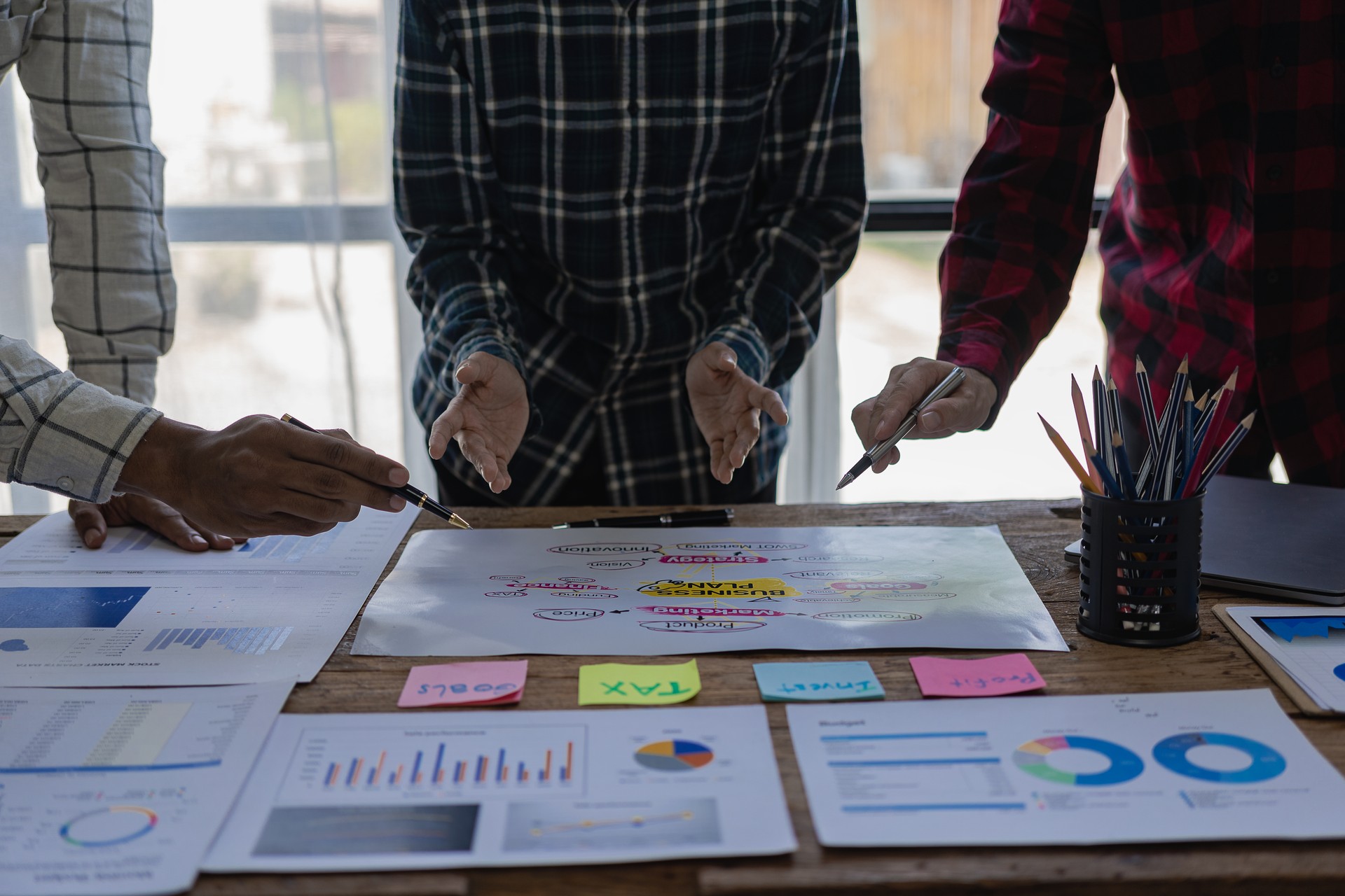 Startup entrepreneurs are discussing brainstorming together, a new start-up project in an alliance's business meeting with graphed documents while sitting at the office together. Remote Picture